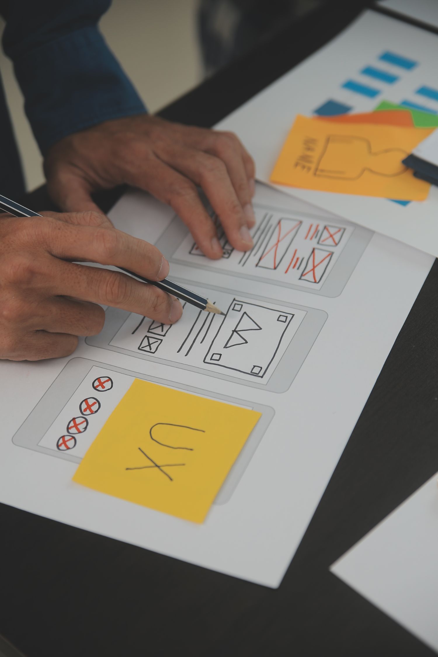 Close up ux developer and ui designer brainstorming about mobile app interface wireframe design on table with customer brief and color code at modern office Creative digital development agency